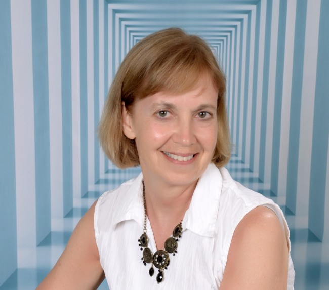 A blue and white striped tunnel in the background with Julie Stobbe in the foreground wearing a white blouse.