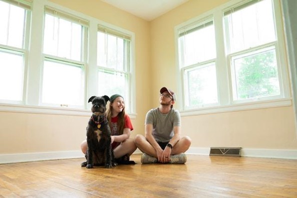 A couple sitting on the floor in a new home.